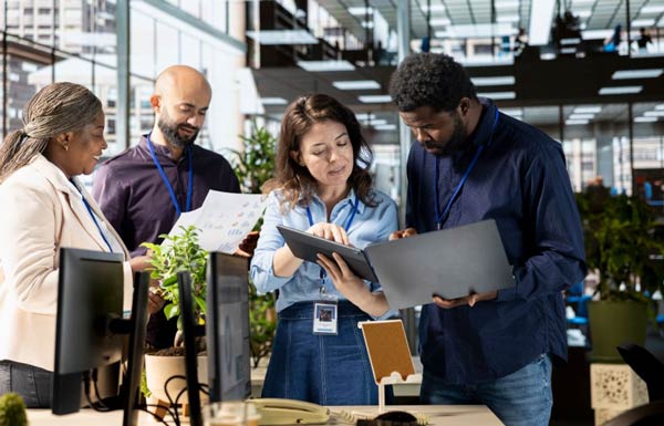 4-personnes-qui-regarde-une-tablette-et-des-documents